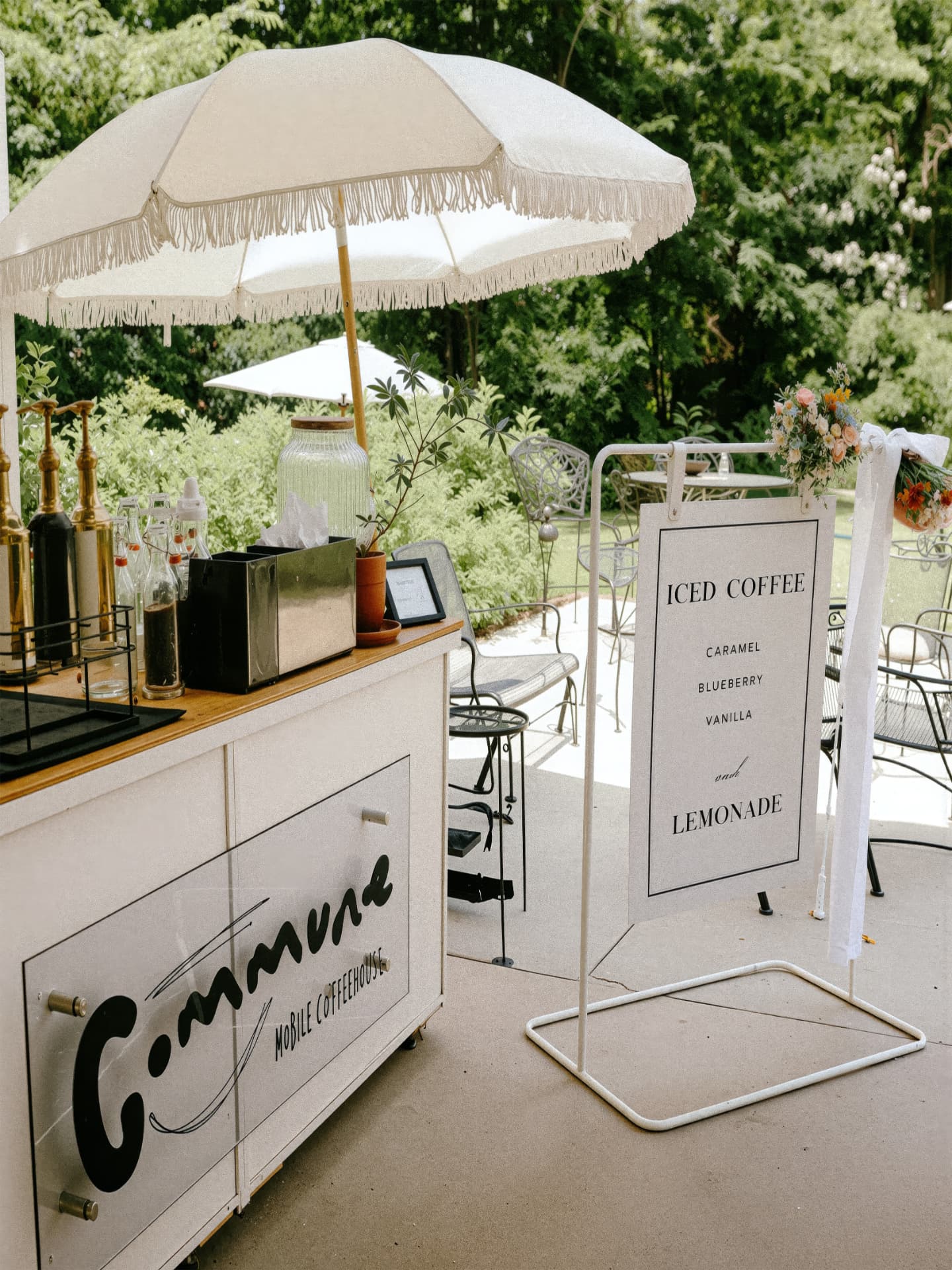 The Commune mobile coffee cart set up outdoors under a fringed umbrella